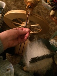 Karla spinning wool from the comb, carding the wool as she goes.