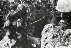 A Marine advances on a cave on Saipan (National Archives, Marine Corps)