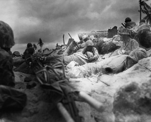 Marines seek cover amongst the dead and wounded behind the sea wall on Red Beach 3, Tarawa. (National Archives, Marine Corps)